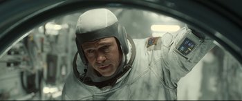 Movie still from “Ad Astra” (2019), directed by James Gray – A man in a spacesuit and helmet in a space suit; Close Up shot, Overhead angle