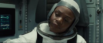 Movie still from “Ad Astra” (2019), directed by James Gray – A woman in a space suit is sitting in a chair; Close Up shot, High angle