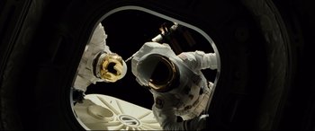 Movie still from “Ad Astra” (2019), directed by James Gray – An image of an astronaut in the space; Medium shot, Overhead angle