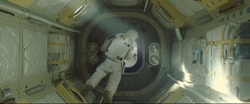 Movie still from “Ad Astra” (2019), directed by James Gray – A person in a spacesuit inside of a space station; Wide shot, Overhead angle