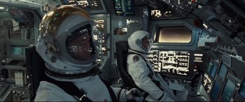 Movie still from “Ad Astra” (2019), directed by James Gray – Two men in spacesuits are sitting in the cockpit of a space ship; Medium shot, Overhead angle