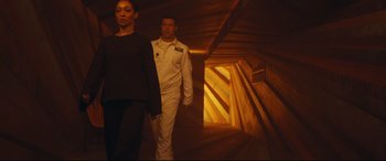 Movie still from “Ad Astra” (2019), directed by James Gray – A man and a woman walking down a wooden staircase; Wide shot, Low angle