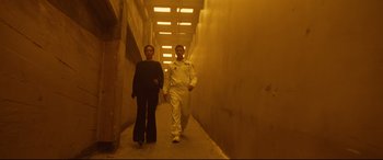 Movie still from “Ad Astra” (2019), directed by James Gray – A man and a woman are walking down a hallway; Wide shot, Low angle