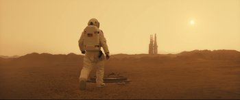 Movie still from “Ad Astra” (2019), directed by James Gray – A person in a spacesuit standing on a dirt field; Wide shot, Low angle