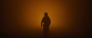Movie still from “Ad Astra” (2019), directed by James Gray – A person standing in the middle of a dark room; Wide shot, Low angle