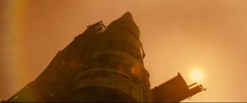 Movie still from “Ad Astra” (2019), directed by James Gray – A tall building with a sky filled with lots of smoke; Extreme Wide shot, Low angle