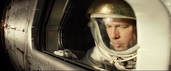 Movie still from “Ad Astra” (2019), directed by James Gray – A man in a spacesuit looking out of a window; Close Up shot, Overhead angle