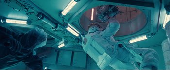Movie still from “Ad Astra” (2019), directed by James Gray – A man in a spacesuit in an outer space station; Wide shot, Overhead angle