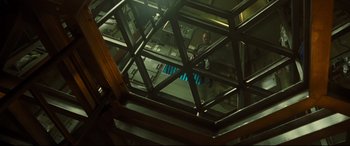 Movie still from “Ad Astra” (2019), directed by James Gray – A man standing inside of a building looking out the window; Wide shot, Overhead angle