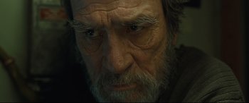 Movie still from “Ad Astra” (2019), directed by James Gray – An old man with a gray beard stares at the camera; Close Up shot, Low angle
