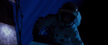 Movie still from “Ad Astra” (2019), directed by James Gray – A man in a space suit is sitting in the dark; Wide shot, Overhead angle