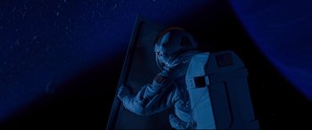 Movie still from “Ad Astra” (2019), directed by James Gray – A person in a spacesuit standing on a metal platform; Medium shot, Overhead angle