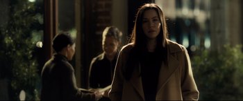 Movie still from “Ad Astra” (2019), directed by James Gray – A woman is walking down the street in the dark; Medium shot, Over the shoulder angle