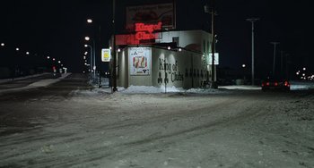 Movie still from “Fargo” (1996), directed by Ethan Coen – A king of clubs sign on the side of a building; Extreme Wide shot, High angle