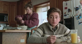 Movie still from “Fargo” (1996), directed by Ethan Coen – A young boy sitting at a table with a bowl in front of a woman; Medium shot, Over the shoulder angle