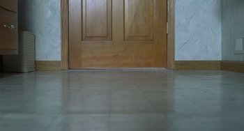 Movie still from “Fargo” (1996), directed by Ethan Coen – A large wooden door in the middle of a room; Wide shot, High angle