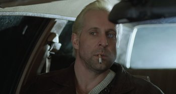Movie still from “Fargo” (1996), directed by Ethan Coen – A man smoking a cigarette while sitting in a car; Close Up shot, Low angle