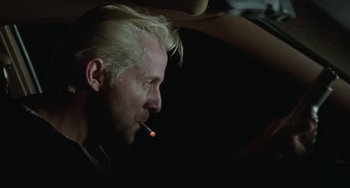 Movie still from “Fargo” (1996), directed by Ethan Coen – A man smoking a cigarette in a dark room; Close Up shot, Low angle