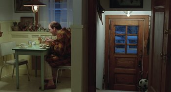Movie still from “Fargo” (1996), directed by Ethan Coen – A man sitting at a dinner table eating; Wide shot, High angle
