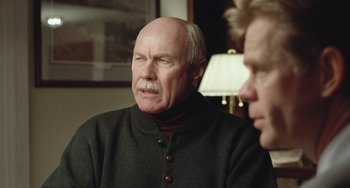 Movie still from “Fargo” (1996), directed by Ethan Coen – An older man wearing a black sweater and a red shirt; Close Up shot, Over the shoulder angle