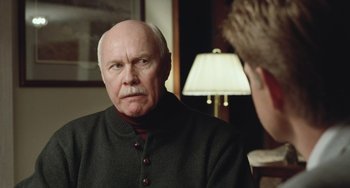 Movie still from “Fargo” (1996), directed by Ethan Coen – An older man is looking at a younger man; Close Up shot, Over the shoulder angle