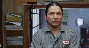 Movie still from “Fargo” (1996), directed by Ethan Coen – A man in a gray shirt is looking at the camera; Close Up shot, Low angle