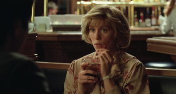 Movie still from “Fargo” (1996), directed by Ethan Coen – A woman sitting at a table with a drink in her hand; Close Up shot, Low angle