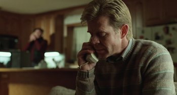 Movie still from “Fargo” (1996), directed by Ethan Coen – A man talking on a cell phone while sitting in a room; Close Up shot, Low angle