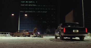 Movie still from “Fargo” (1996), directed by Ethan Coen – A man laying on the ground next to a car; Extreme Wide shot, High angle