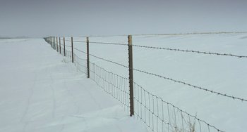 Movie still from “Fargo” (1996), directed by Ethan Coen – A barbed wire fence in the middle of a snow covered field; Extreme Wide shot, Low angle