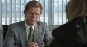 Movie still from “Fargo” (1996), directed by Ethan Coen – A man wearing a suit and tie sitting in front of another man in a suit; Close Up shot, Over the shoulder angle