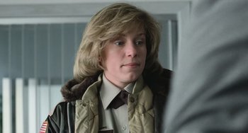 Movie still from “Fargo” (1996), directed by Ethan Coen – A woman with blonde hair wearing a jacket and a tie; Close Up shot, Low angle