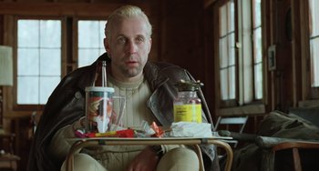 Movie still from “Fargo” (1996), directed by Ethan Coen – A man sitting at a table with a tray of food; Medium shot, Low angle