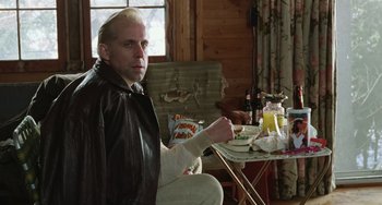 Movie still from “Fargo” (1996), directed by Ethan Coen – A man sitting at a table in a living room; Medium shot, Low angle