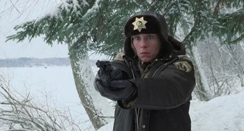 Movie still from “Fargo” (1996), directed by Ethan Coen – A woman holding a handgun while standing next to a tree; Medium shot, Low angle