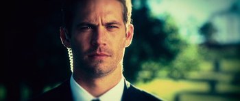 Movie still from “Fast & Furious 6” (2013), directed by Justin Lin – A person wearing a suit and tie; Close Up shot, Over the shoulder angle