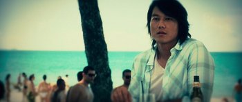 Movie still from “Fast & Furious 6” (2013), directed by Justin Lin – A man standing next to a tree near the ocean; Close Up shot, Over the shoulder angle