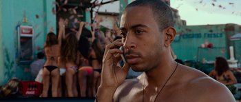 Movie still from “Fast & Furious 6” (2013), directed by Justin Lin – A shirtless man on a cell phone in front of a crowd of people; Close Up shot, Over the shoulder angle
