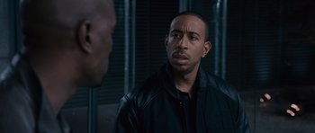 Movie still from “Fast & Furious 6” (2013), directed by Justin Lin – A man wearing a leather jacket looking at a man in a black jacket; Close Up shot, Over the shoulder angle