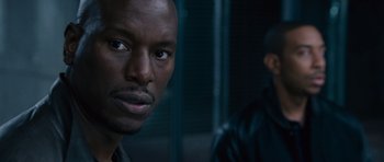Movie still from “Fast & Furious 6” (2013), directed by Justin Lin – A man's face in front of another man; Close Up shot, Over the shoulder angle