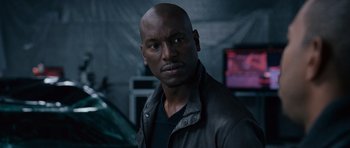 Movie still from “Fast & Furious 6” (2013), directed by Justin Lin – A man in a black shirt and a leather jacket; Close Up shot, Over the shoulder angle