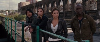 Movie still from “Fast & Furious 6” (2013), directed by Justin Lin – A group of people standing next to a railing; Medium shot, High angle