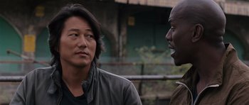 Movie still from “Fast & Furious 6” (2013), directed by Justin Lin – A man and a man standing next to each other; Close Up shot, Over the shoulder angle