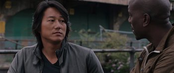 Movie still from “Fast & Furious 6” (2013), directed by Justin Lin – A person wearing a leather jacket; Close Up shot, Over the shoulder angle