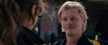 Movie still from “Fast & Furious 6” (2013), directed by Justin Lin – A man with blonde long hair and a smirk on his face; Close Up shot, Over the shoulder angle