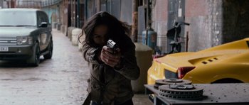 Movie still from “Fast & Furious 6” (2013), directed by Justin Lin – A woman is holding a gun in her hand; Medium shot, High angle