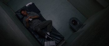 Movie still from “Fast & Furious 6” (2013), directed by Justin Lin – A man sitting on top of a black leather couch; Wide shot, Overhead angle