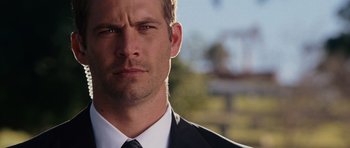 Movie still from “Fast & Furious 6” (2013), directed by Justin Lin – A person wearing a suit and tie; Close Up shot, Over the shoulder angle