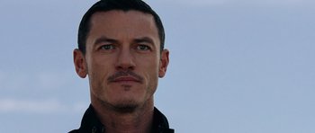 Movie still from “Fast & Furious 6” (2013), directed by Justin Lin – A person with a beard; Close Up shot, Over the shoulder angle