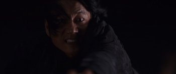 Movie still from “Fast & Furious 6” (2013), directed by Justin Lin – A person with a black jacket is holding a gun; Close Up shot, Low angle